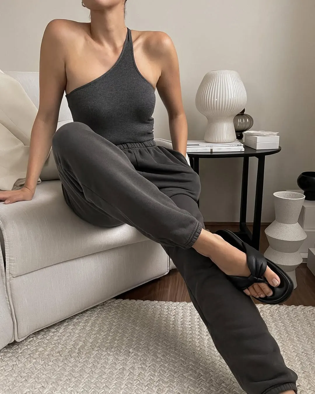 woman wearing one-shoulder grey tank and matching pants