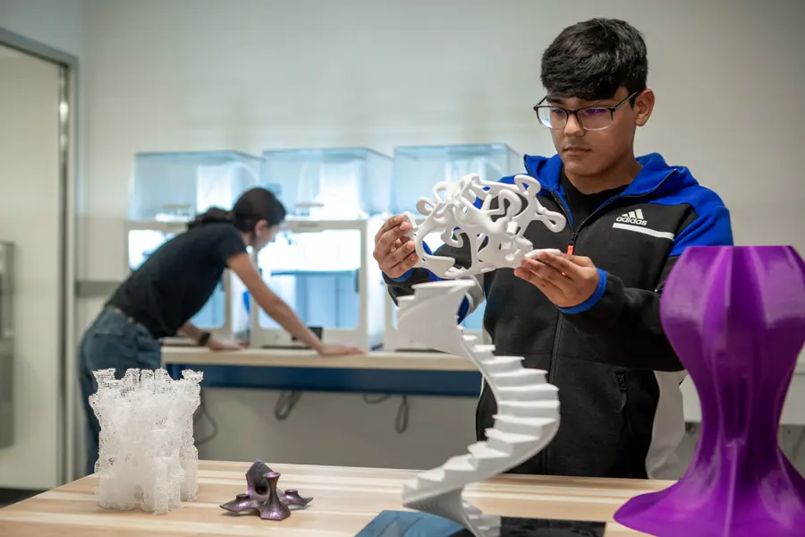 Two students create 3-D printed projects in New York Tech's Fab Lab.