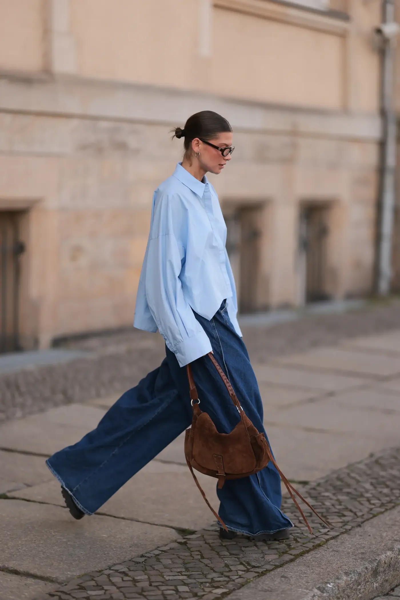 Image may contain Clothing Pants Person Walking Jeans Accessories Bag Handbag Adult Footwear Shoe and Blazer