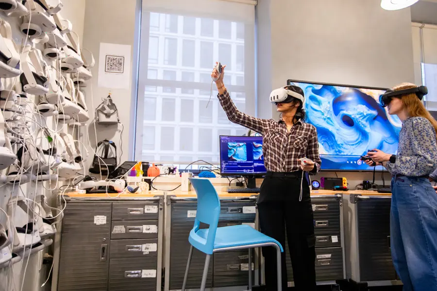 Two students use virtual reality goggles in New York Tech's Home for Innovation, Visualization, and Exploration.