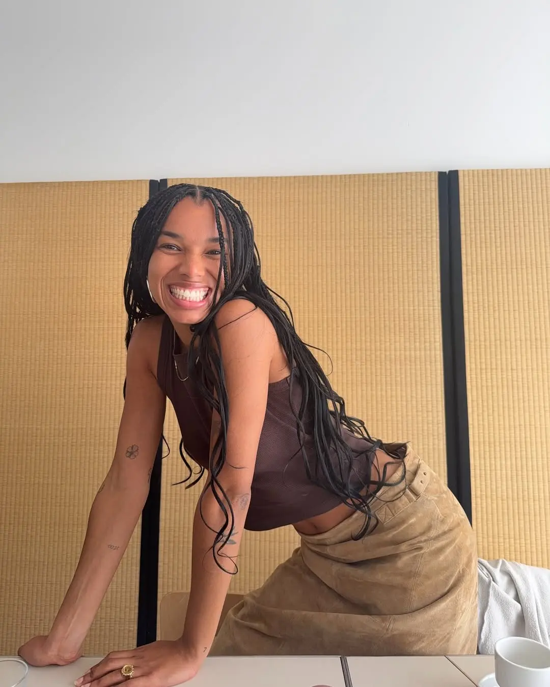 Fia wears brown suede skirt and tank top