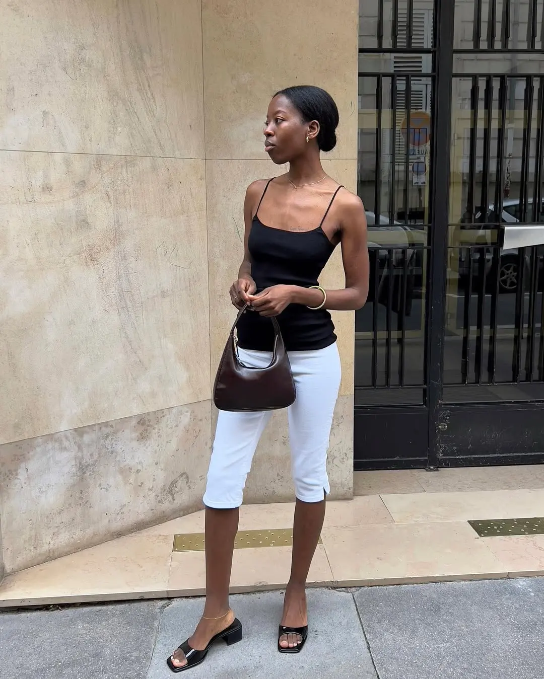 woman wearing black tank top and white pedal pushers summer outfit 2025