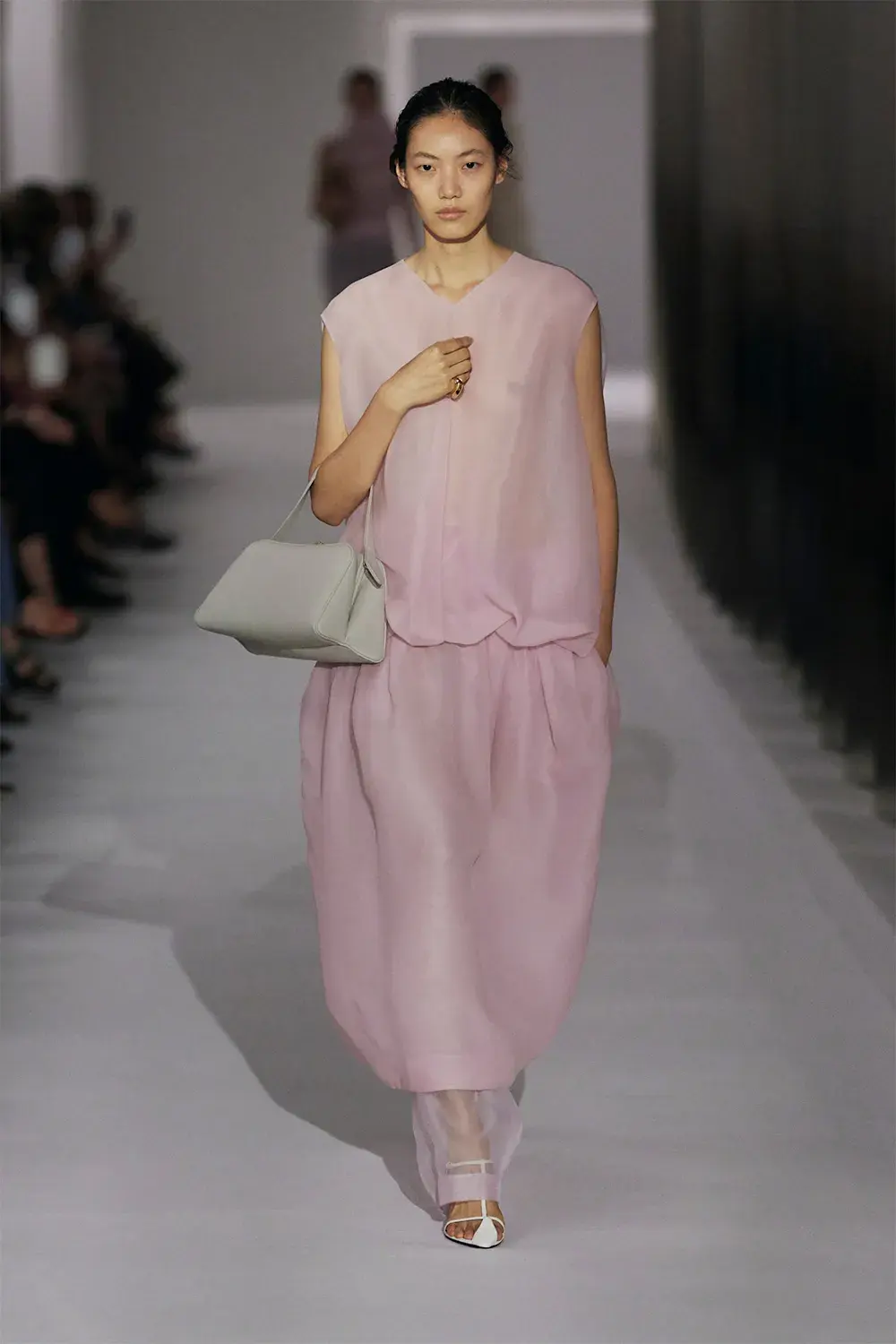 model wears floaty pink dress on catwalk