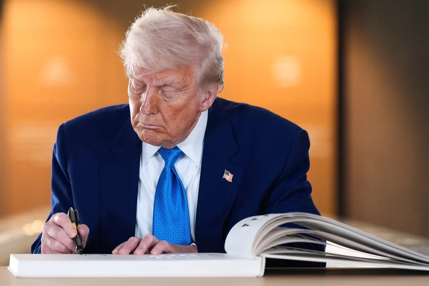 Trump signs the guest book after touring the Abrahamic Family House in Abu Dhabi