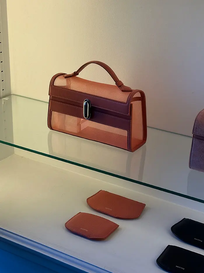 Savette bag on a clear glass shelf.