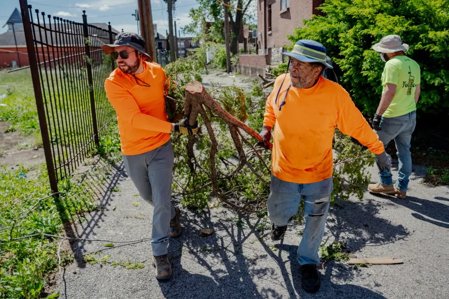 Alex Cadigan, of Affton, left, helps Sam Campbell, haul a large tree limb in north St. Louis on Saturday, May 17, 2025 — the day after an EF-3 tornado ripped through the central and northern corridor of St. Louis on Friday.