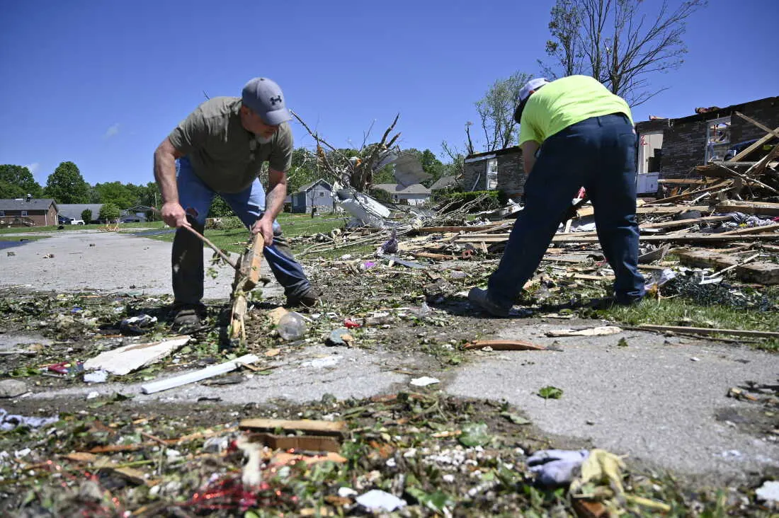 Volunteers help clear debris from a road following severe storms last night in London, Ky., Saturday, May 17, 2025. (AP Photo/Timothy D. Easley)