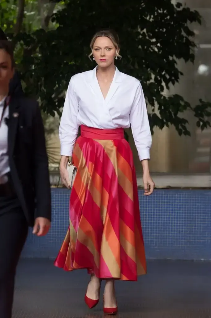 Princess Charlene in a striped skirt and red heels
