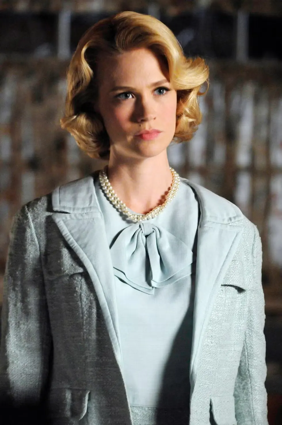 a blonde woman in a blue dress and coat