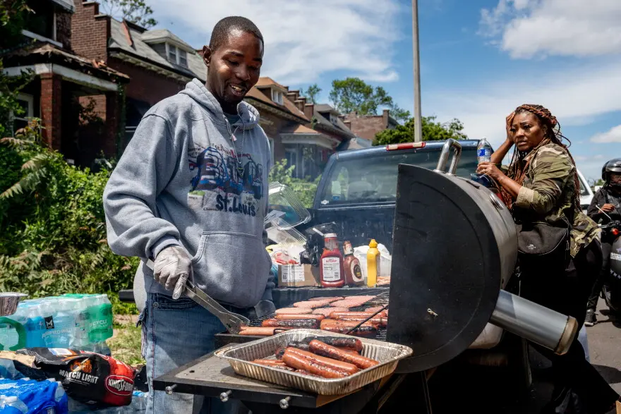 Sam Mosley, of Jennings, grills hot dogs and burgers on Saturday, May 17, 2025, in north St. Louis. Mosley and a group of volunteers made free food for area residents who suffered the impacts of an EF-3 tornado ripping through the city on Friday night, killing at least 5 and damaging hundreds of homes.